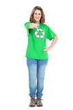 Cheerful woman wearing recycling tshirt pointing at camera