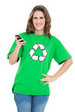 Smiling environmental activist holding phone looking at camera