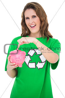 Environmental activist pointing at piggy bank