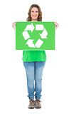 Smiling environmental activist holding recycling sign looking at camera