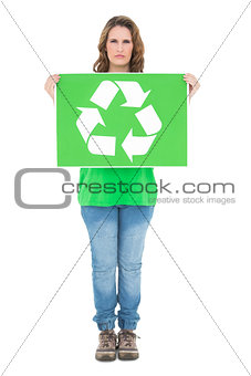 Environmental activist holding recycling sign looking at camera