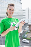 Smiling woman wearing recycling tshirt holding tablet