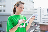 Smiling woman wearing recycling tshirt using tablet