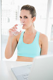 Fit woman in sportswear drinking water