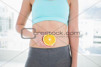 Woman in sportswear holding orange
