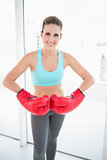 Competitive woman wearing red boxing gloves
