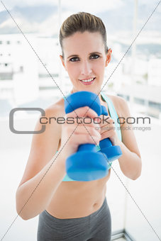 Fit woman exercising with dumbbell