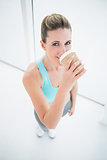 Fit woman in sportswear drinking coffee