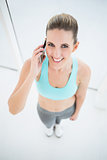 Smiling woman in sportswear talking on the phone