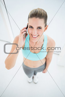 Smiling woman in sportswear talking on the phone