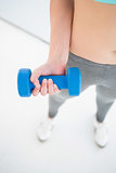 Woman in sportswear exercising with dumbbell