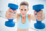 Serious woman exercising with dumbbells