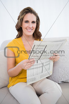 Smiling woman holding newspaper