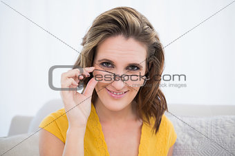 Attractive woman wearing glasses sitting on sofa