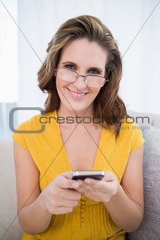 Happy woman with glasses holding phone