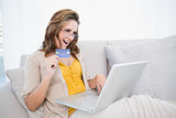 Cheerful blonde woman doing online shopping