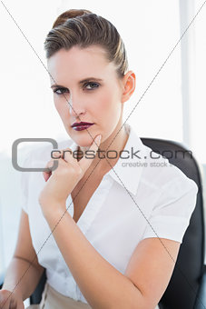 Serious businesswoman working looking at camera