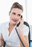Happy businesswoman sitting talking on the phone