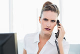 Frowning classy businesswoman talking on the phone