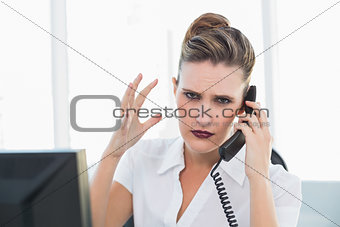 Angry businesswoman talking on the phone