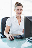 Smiling classy businesswoman working on computer