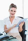 Smiling businesswoman using her tablet pc