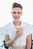 Happy businesswoman holding cup of coffee