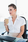 Thoughtful businesswoman holding coffee