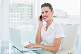 Happy businesswoman talking on the phone while looking at camera