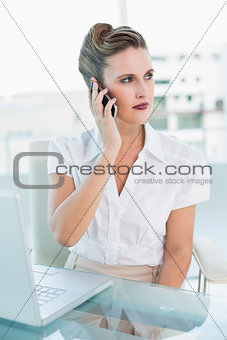 Unsmiling businesswoman talking on the phone