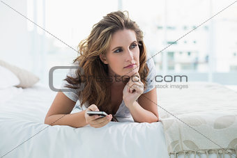 Thoughtful woman resting in bed