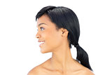 Profile view of a joyful black haired woman posing looking away