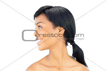 Profile view of a joyful black haired woman posing looking away