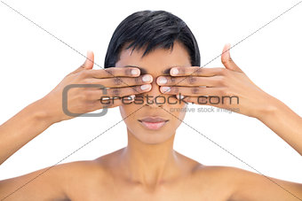 Serious black haired woman covering her eyes