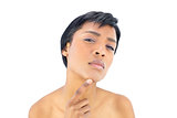 Thoughtful black haired woman posing with a finger on her chin
