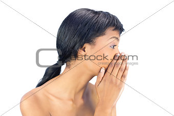 Attractive black haired woman covering her mouth with both hands