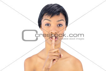Cute black haired woman posing with finger on the mouth