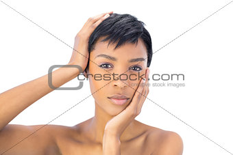 Unsmiling black haired woman holding her head