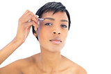 Beautiful black haired woman plucking her eyebrows