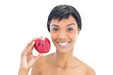 Pleased black haired woman holding an apple