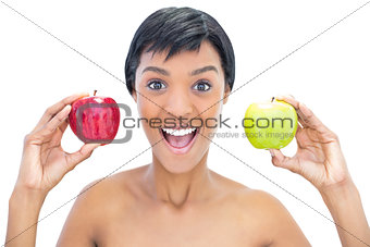 Cheerful black haired woman holding apples