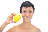 Natural black haired woman holding an orange