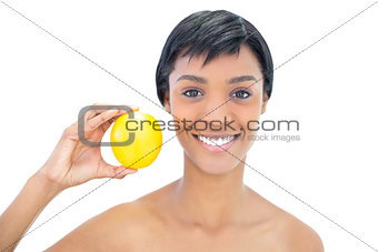 Natural black haired woman holding an orange