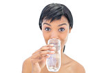 Lovely black haired woman drinking a glass of water