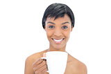 Content black haired woman holding a cup of coffee
