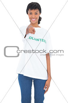 Joyful black haired volunteer pointing the camera with her finger