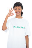 Cheerful black haired volunteer making an okay gesture