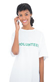 Attractive black haired volunteer calling someone with her mobile phone