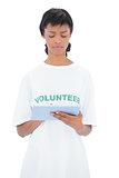Thoughtful black haired volunteer using a tablet pc