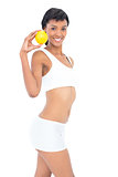 Dynamic fit woman posing holding an orange